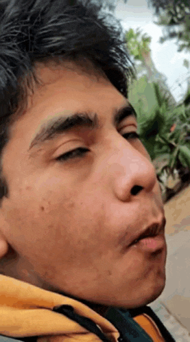 a close up of a young man 's face with his mouth open and his eyes closed .