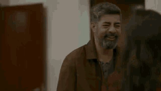 a man with a beard is laughing with a woman .