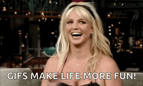 britney spears is laughing while sitting on a couch .