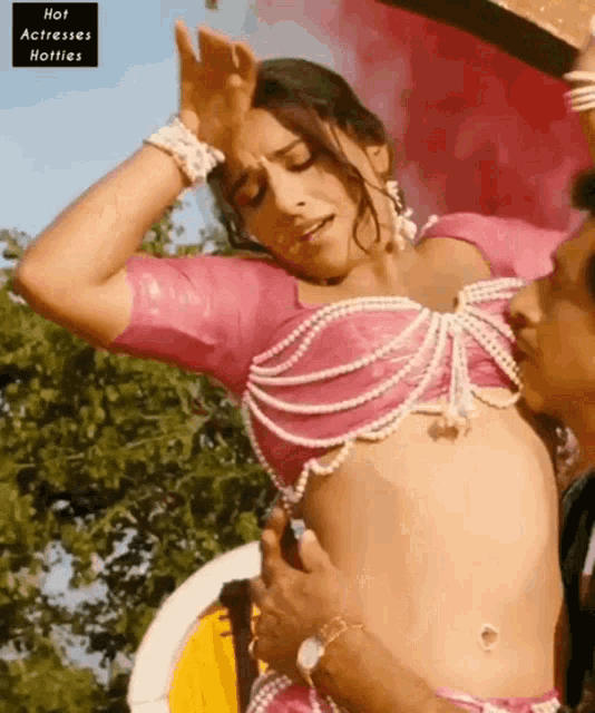 a woman in a pink top is being touched by a man with the words hot actresses hotties on the bottom