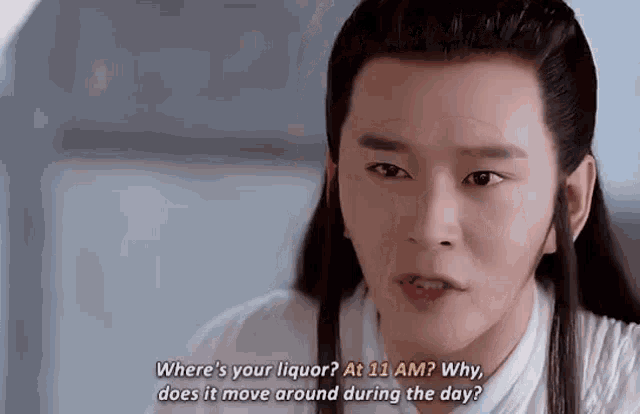 a man with long hair and a white shirt is talking to someone .