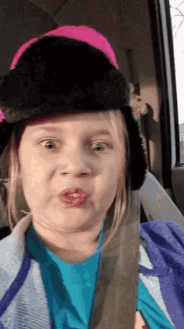 a girl wearing a black hat and a blue shirt
