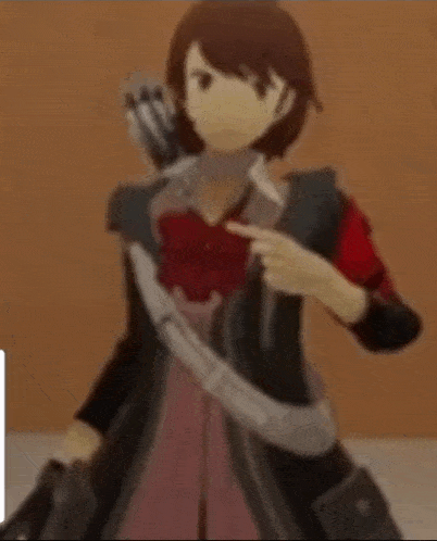 a doll with a red armband on her arm is standing in front of a wall .