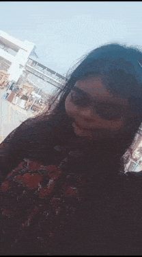 a young girl is taking a selfie in front of a bridge .
