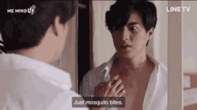 a man in a white shirt is looking at himself in a mirror and says just mosquito bites
