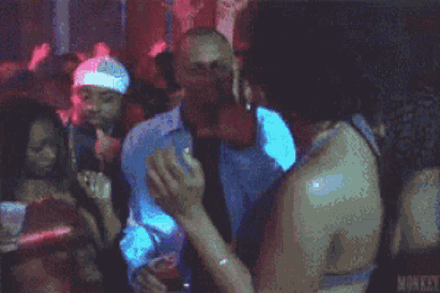 a group of people are dancing in a club