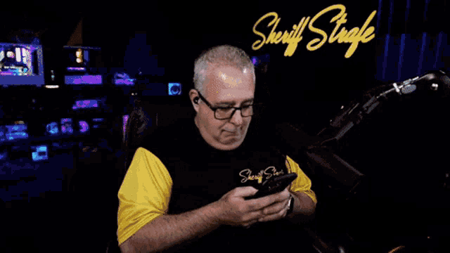 a man sitting in front of a neon sign that says sheriff strafe