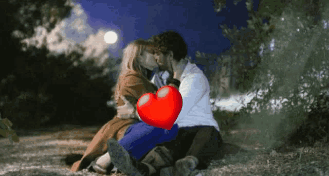 a man and a woman kissing with a red heart in the background