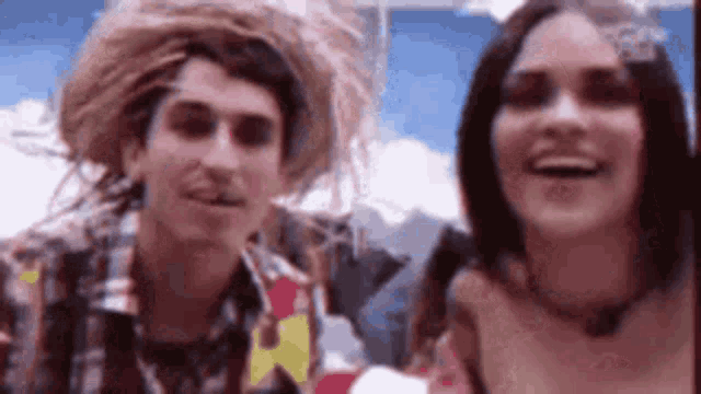 a man and a woman are standing next to each other and smiling at the camera .