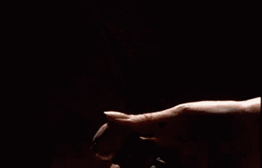 a close up of a person spraying a bottle of perfume on their hand .