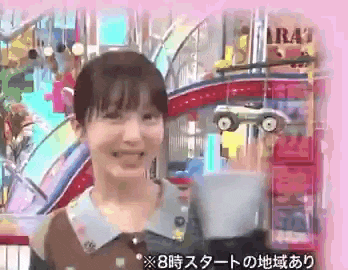 a woman is smiling in front of a roller coaster and a sign that says ' a ' on it .