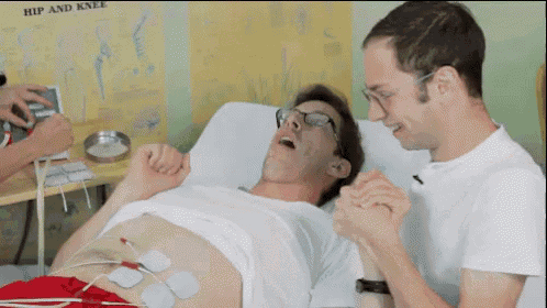 a man is laying in a hospital bed with a hip and knee diagram behind him