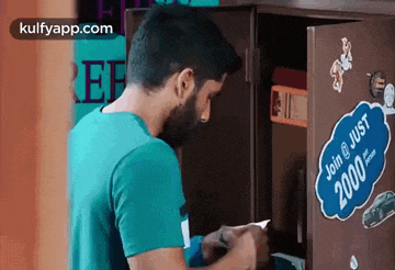 a man is writing on a piece of paper in a safe with a sticker that says join just 2000