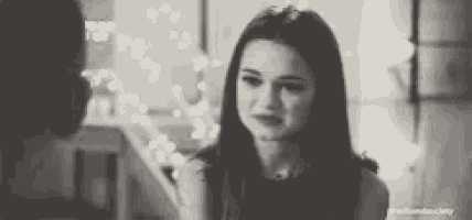 a woman in a black and white photo is looking at a man .