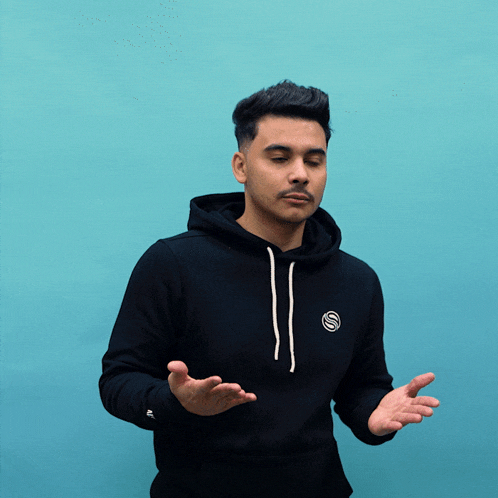 a man wearing a black hoodie with a s on it