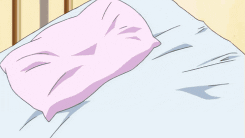 a girl in a blue shirt is laying on a bed with a pink pillow