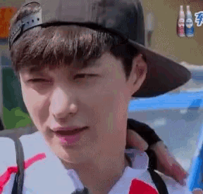 a close up of a young man wearing a hat and a backpack .