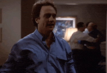 a man in a white shirt and black tie is standing in a dark room