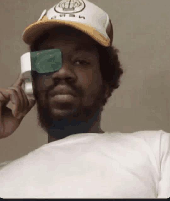a man wearing a hat that says ash on it talking on a cell phone
