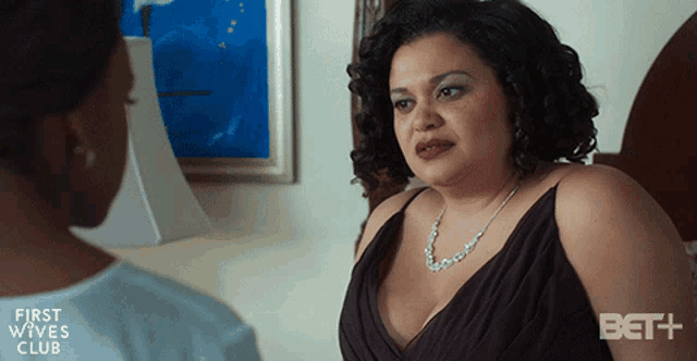 a woman in a black dress is talking to another woman in a first wives club advertisement