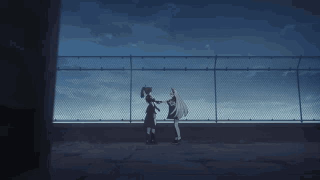 two anime girls are standing next to each other in front of a chain link fence .