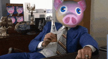 a man in a blue suit has a pig mask on his face