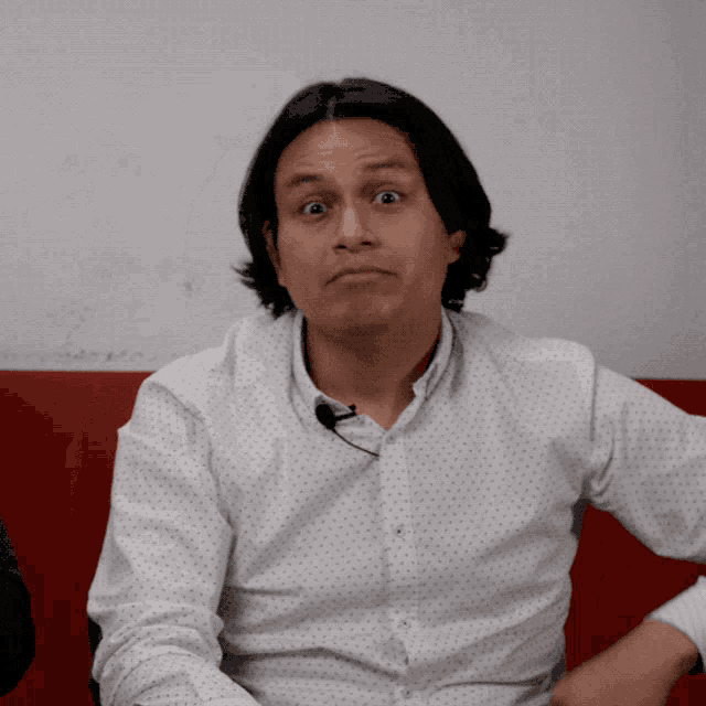 a man with a microphone around his neck makes a face