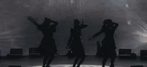 a group of women are dancing on a stage in front of a wall .