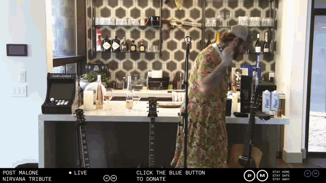 a man playing a guitar in front of a screen that says post malone