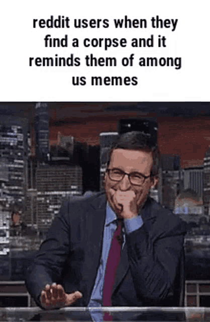 a man in a suit and tie is sitting at a table laughing .