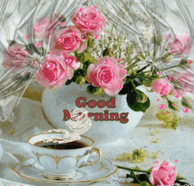 a cup of coffee sits next to a vase of flowers that says good morning