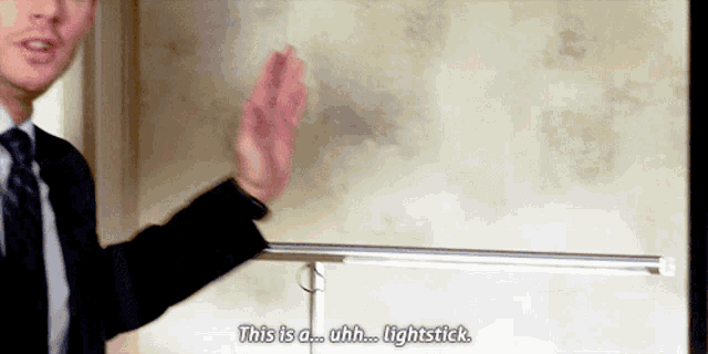 a man in a suit and tie says " this is a lightstick "
