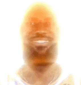 a blurry picture of a man 's face with a beard and a smile .