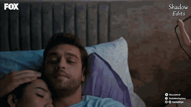 a man and a woman laying in bed with the fox logo on the bottom right