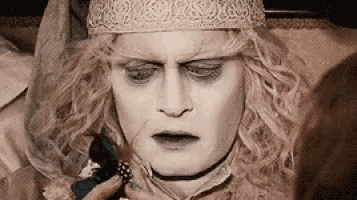 a close up of a person 's face with a crown on their head .