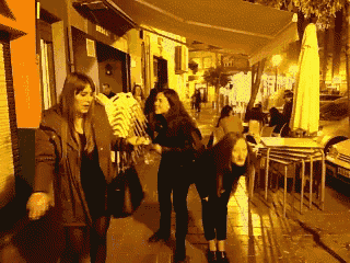 a group of women are walking down a sidewalk in front of a restaurant with a sign that says ' ibiza ' on it