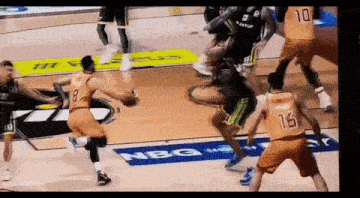 a basketball game is being played on a court with a nbg banner on the floor