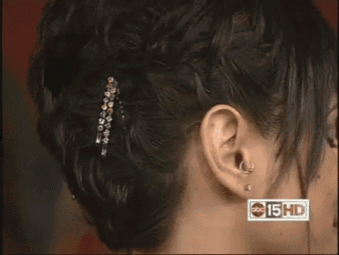 a close up of a woman 's ear with the abc 15 hd logo visible