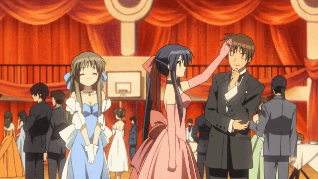 a man in a tuxedo and a woman in a pink dress are dancing in a ballroom