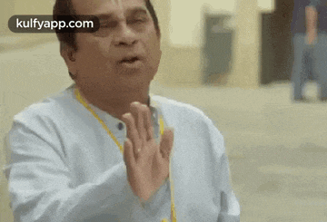 a man is making a funny face with his hands in front of his face .