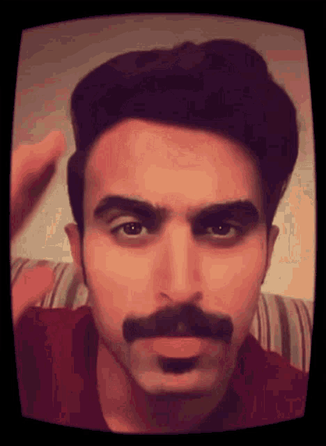 a man with a mustache is making a face