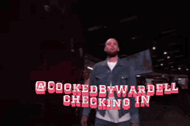 a man in a denim jacket stands in front of a sign that says cooked by wardell checking in