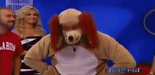 a man in a dog costume is standing in front of a group of people .