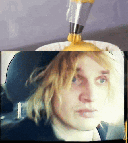 a close up of a man 's face with a yellow sauce pouring on it