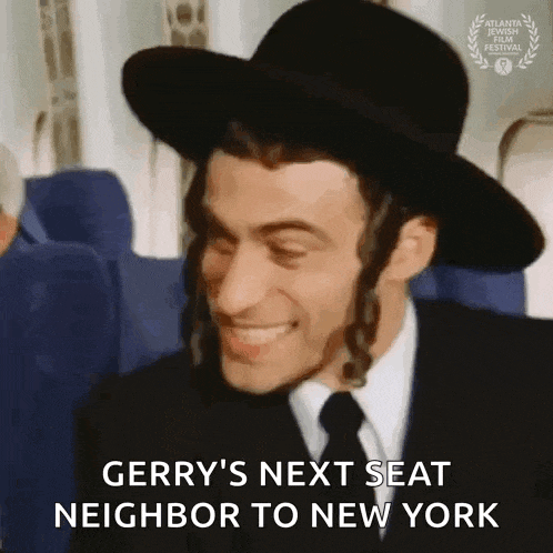 a man wearing a hat and tie is smiling while sitting on a plane .