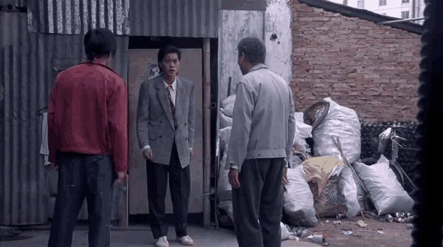 a man in a suit is standing in front of a brick wall