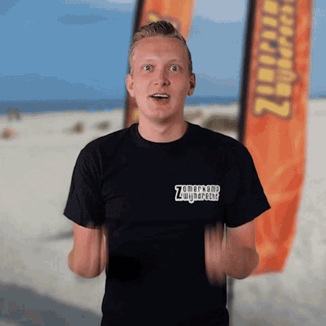 a man wearing a black shirt that says " zomerkamp zwijnaarde "