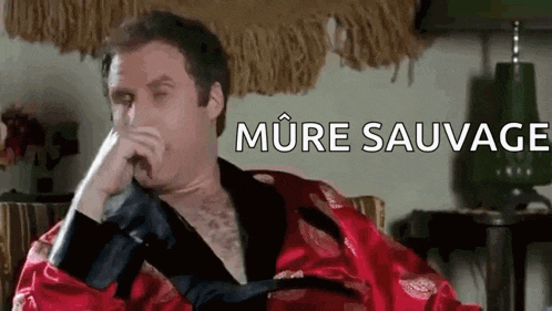 a man in a robe is sitting in a chair with his hand on his face and the words `` more sauvage '' behind him .