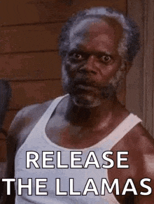a man with a beard and a white tank top is standing in front of a building and says `` release the llamas '' .