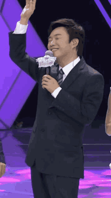 a man in a suit and tie is holding a microphone with a label that says ' a ' on it